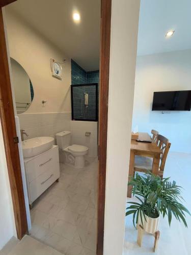 a bathroom with a sink and a toilet and a table at Langbaan cafe and homestay in Ban Mai