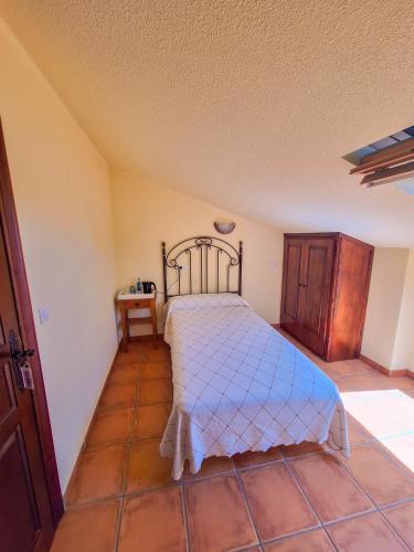 a bedroom with a bed and a wooden cabinet at Hotel-Albergue Puente Fitero in Itero de la Vega