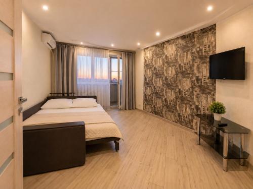 a bedroom with a bed and a flat screen tv at Luxury 3 Rooms Apartments in Center by Green House in Poltava