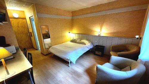 a small room with a bed and two chairs at Le Terminus in Ax-les-Thermes