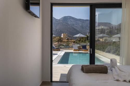 a bedroom with a view of a swimming pool at Celeste Bali Suites in Bali