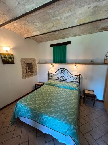 a bedroom with a bed with a green comforter at Il Castello sul Lago in Arrone