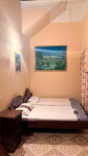 a bed in a room with a picture on the wall at lala salama in Zanzibar City