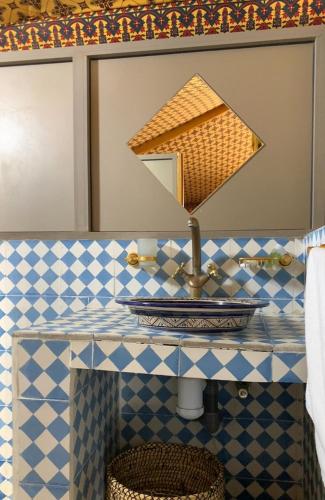 a bathroom counter with a sink and a mirror at Arabian Desert Home in Aït Mazou