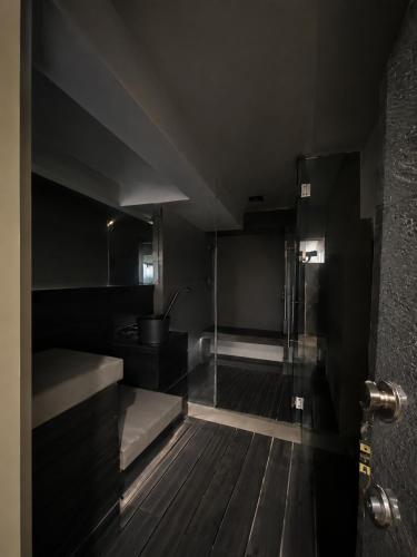 a black bathroom with a shower and a sink at Kanchan Jayanti Villa in Khandāla