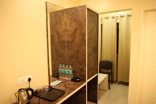 a bathroom with a shower with water bottles on a counter at Kings Residency in Chennai