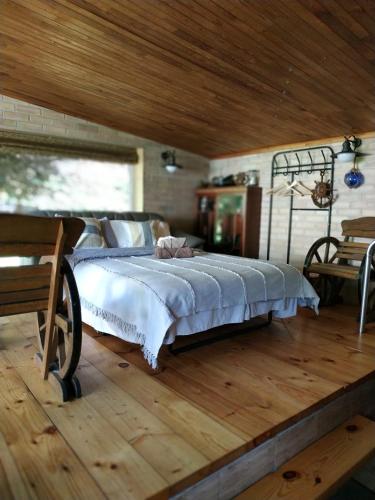 a bed in a room with a wooden floor at 100SaulesVikingi in Grobiņa