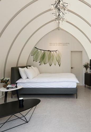 a bedroom with a large bed and a table at Be,Bridge Pool Villa Resort in Yeongwol