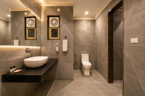 a bathroom with a sink and a toilet at Airport La Sapphire Hotel & Restaurant in New Delhi