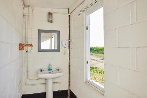 a bathroom with a sink and a window at College Farm by Feather Down in Beccles