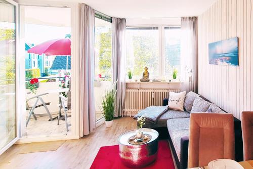 a living room with a couch and a table at Strandliebe in Scharbeutz, 150m zum Strand! Sonnenbalkon, ruhig gelegen, kostenfreier Parkplatz, Fahrstuhl in Scharbeutz