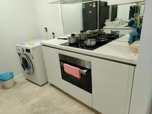 a kitchen with a stove and a washing machine at vortex luxury APATMENT BY FRINDSHIP in Kuala Lumpur