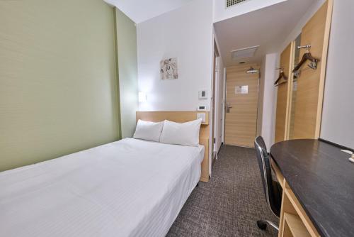 a small room with a bed and a television at Smile Hotel Tokyo Nihonbashi in Tokyo