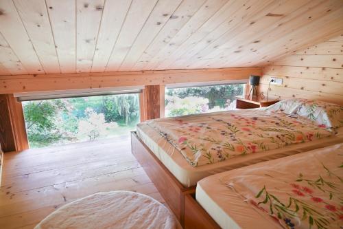 a bedroom with two beds and a large window at Grajski oddih in Cerklje na Gorenjskem