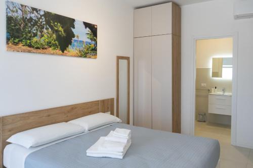 a bedroom with a bed with towels on it at Almarea Cirò Marina in Cirò Marina