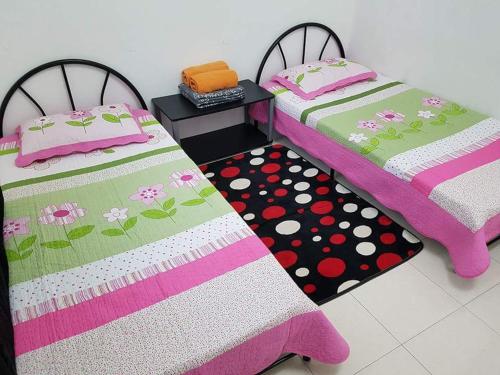 two beds sitting next to each other in a room at Lynn Homestay Jitra in Jitra