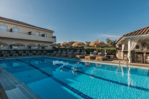 a pool at a hotel with chairs and umbrellas at Agrilia Hotel Adults Only in Laganas