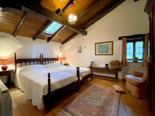 a bedroom with a bed and a chair in a room at Casa rural Garata in Arantza
