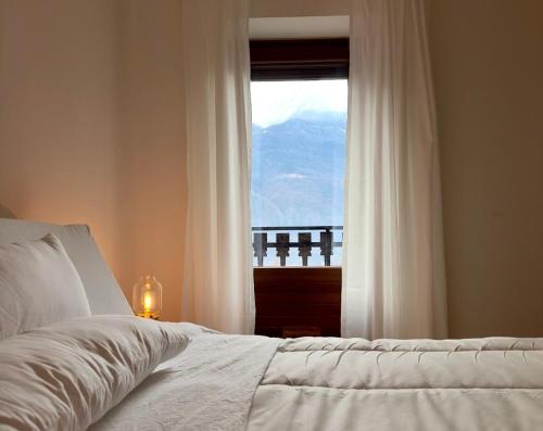 a bedroom with a bed and a window with a view at Maison BelleVue in Châtillon