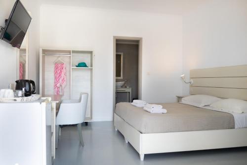 a bedroom with a bed and a desk with a chair at Beach Break Rhodes in Faliraki