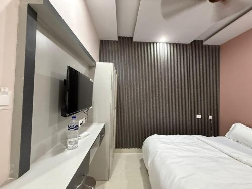 a hotel room with a bed and a flat screen tv at Hotel Pravas Inn in Lucknow
