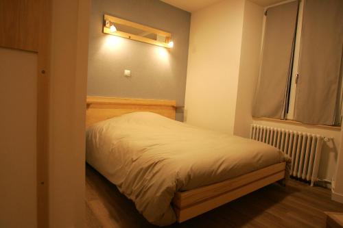 a small bedroom with a bed in a room at Hôtel Bar Restaurant de la Poste Le 1900 in Jougne