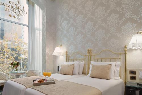 a bedroom with two beds and a window at Hotel Continental Palacete in Barcelona