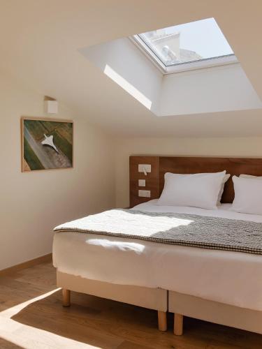 ein Schlafzimmer mit Bett und Dachfenster in der Unterkunft Alfred Hotels Paris Lecourbe- Hôtel Rénové in Paris