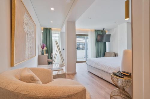 a bedroom with a bed and a couch and a chair at Eternity Athens in Athens