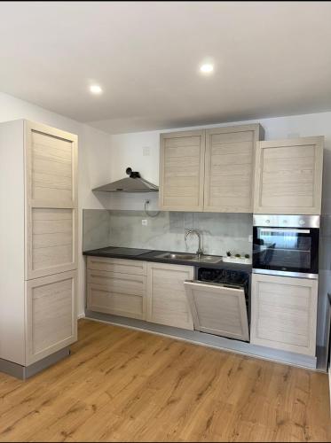 a kitchen with wooden cabinets and a stove top oven at Studio apartman Katja in Karlovac