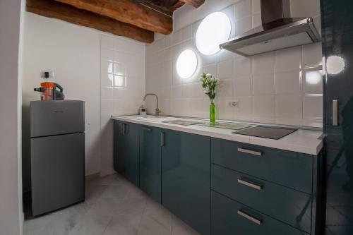 a kitchen with blue cabinets and a refrigerator at Sotto la torre Apartment in Cagliari