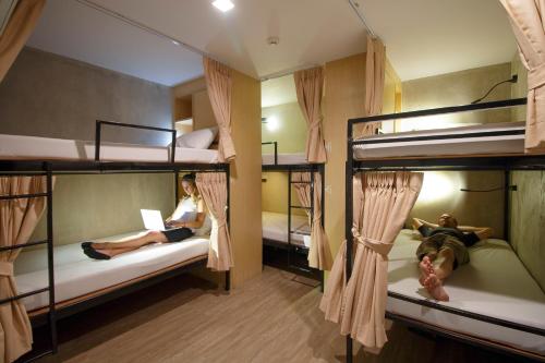 two girls laying on bunk beds in a hostel at Cazz Hostel in Bangkok