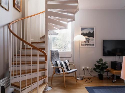 a living room with a staircase and a chair at 2-Story Condo with Terrace in Åre