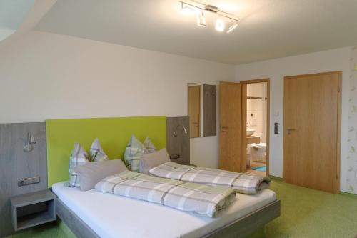 a bedroom with two beds with a green wall at Gästehaus Ainser in Hagnau