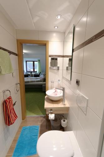 a bathroom with a white toilet and a sink at Gästehaus Ainser in Hagnau