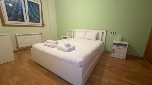 a bedroom with a white bed with towels on it at Oktheway Miño in Miño