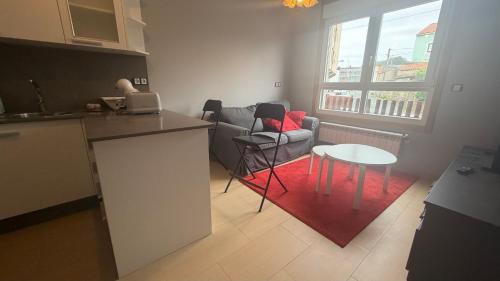 a kitchen and living room with a table and a couch at Oktheway Miño in Miño