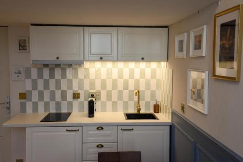 a kitchen with white cabinets and a sink at The Blue Cottage in Nice