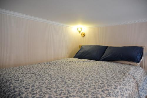 a bedroom with a bed with a light on the wall at The Blue Cottage in Nice