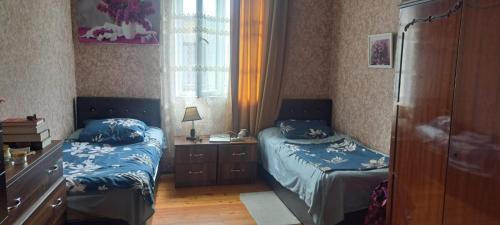 a bedroom with two beds and a desk and a window at Guramishvili 5 in Kobuleti