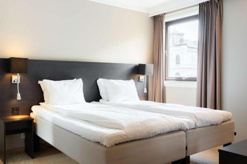 a bedroom with a large white bed with a window at Scandic Stavanger Park in Stavanger