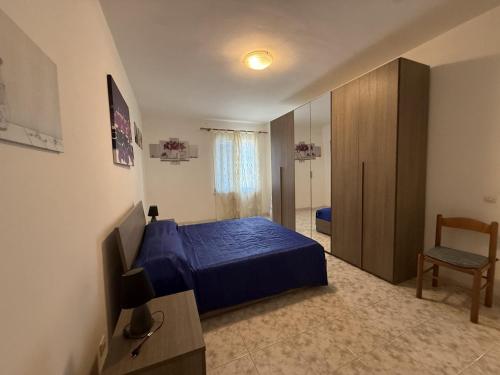 a bedroom with a blue bed and a television at Fiore's house in Porto Santo Stefano