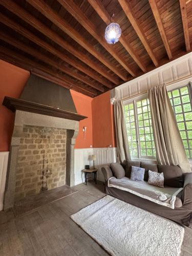 a living room with a couch and a fireplace at Manoir du Moulin Fleury in Villedieu-les-Poêles