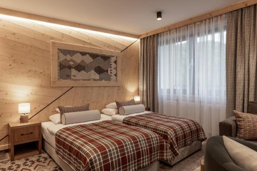 a hotel room with two beds and a window at Apartamenty Solina 67 in Solina