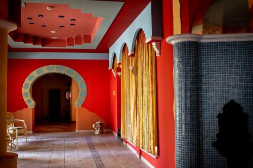 a hallway in a house with red walls at Papuga Park Hotel Wellness Marrakesz & SPA in Bielsko-Biała