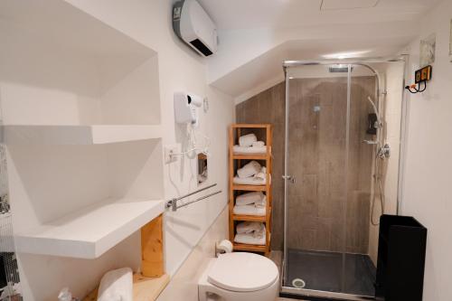 a bathroom with a toilet and a shower at Mariposa cinema in Grumo Appula