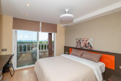 a bedroom with a large bed and a balcony at House close to the beach! Pool, ocean view! in Santa Susanna