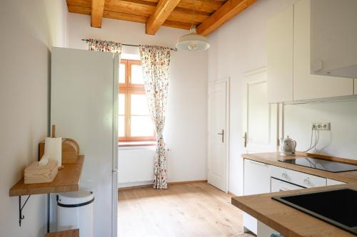a kitchen with white cabinets and a window at Pod Skalou in Temeš