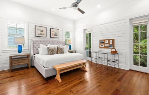 a white bedroom with a bed and a table at Southern Living Cottage in Santa Rosa Beach