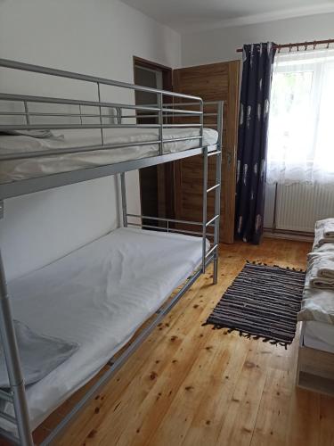 a bedroom with two bunk beds and a wooden floor at Apartmán Slepička in Weissbach